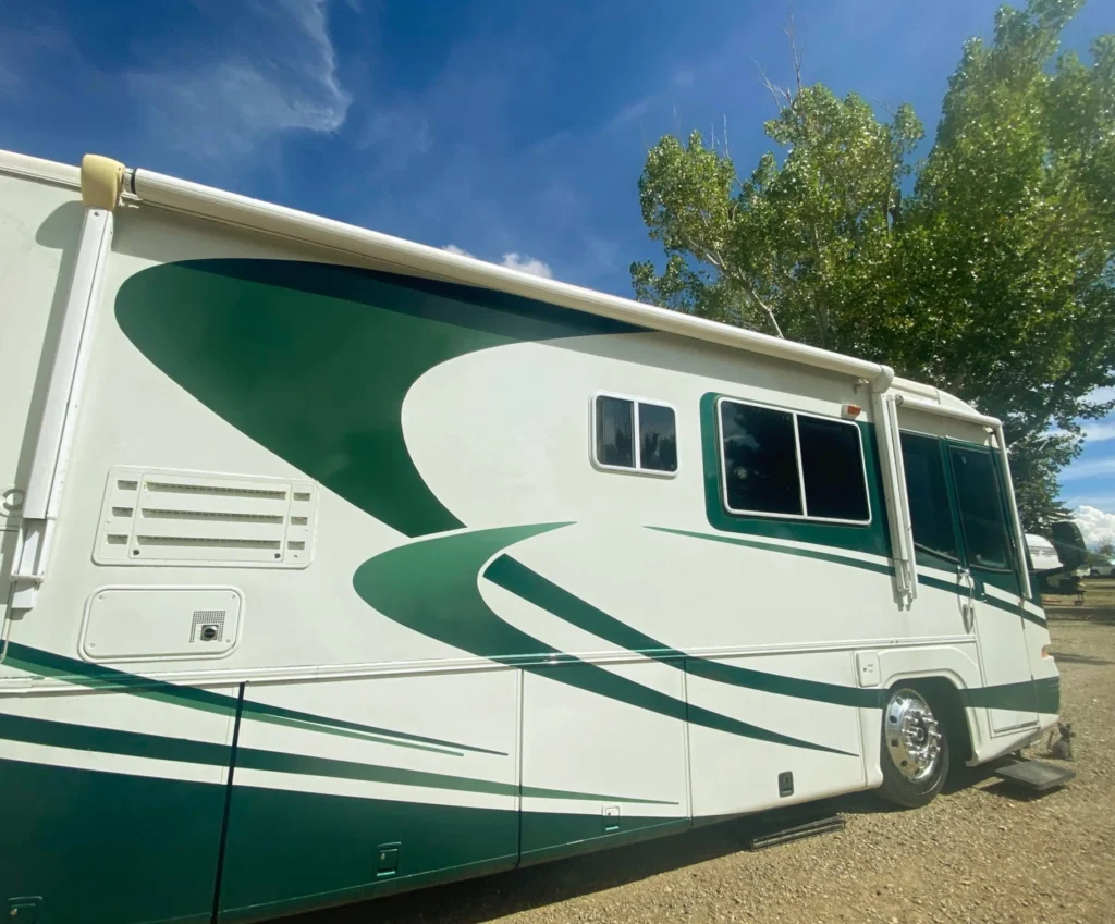 How We Quit the 9-to-5 Grind for Full-Time RV Life The side of a motorhome is lit up highlighting the Green swoosh graphics