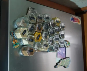 a stainless steel refrigerator door with small spice jars magnetically attached on the door